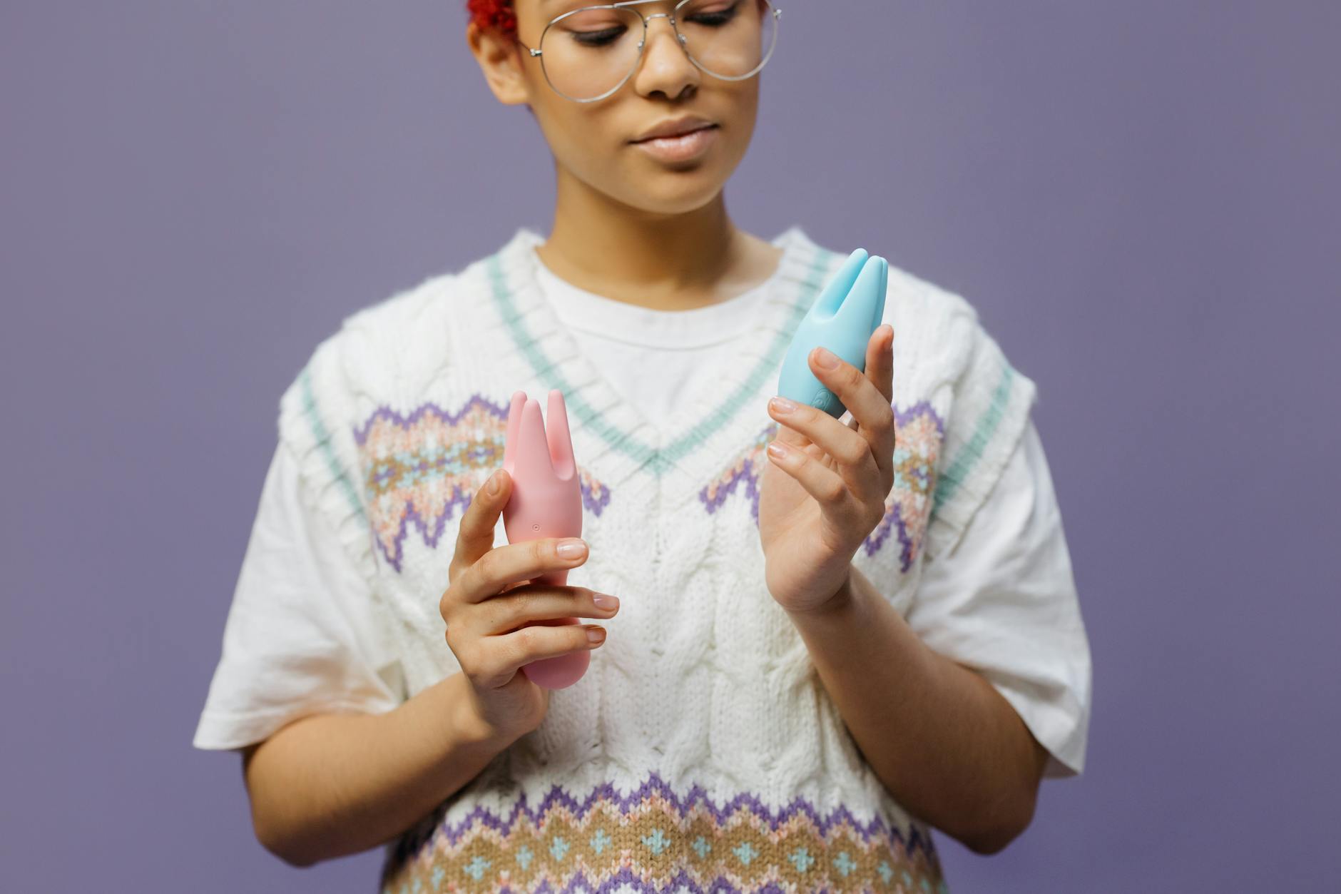 Colorful clitoral vibrators and sex toys arranged on a bright yellow surface, showcasing various designs for pleasure exploration.